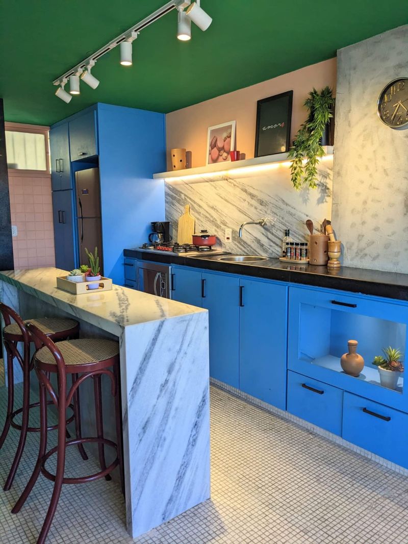 The kitchen island with two stools under a green ceiling