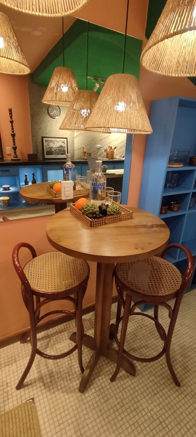 Round table and stools under woven pendant lamps