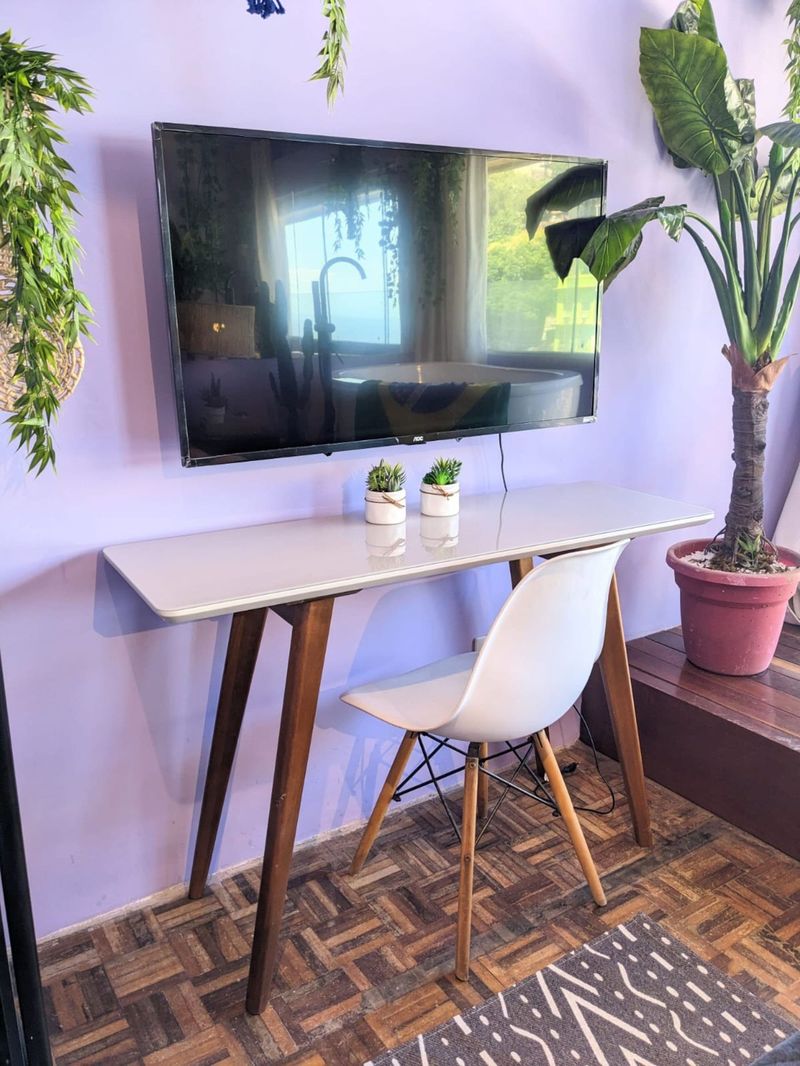 The desk and chair under the wall TV