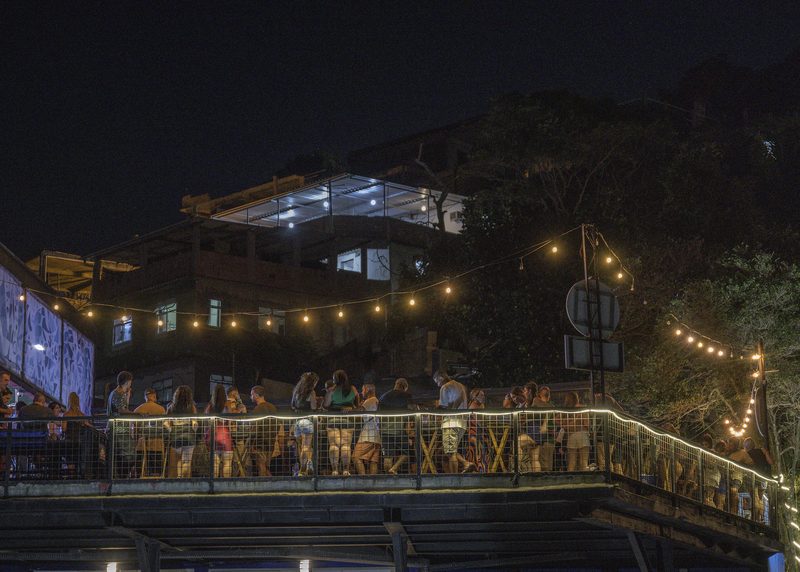 Una multitud en una terraza con luces colgadas, de noche, en Vidigal