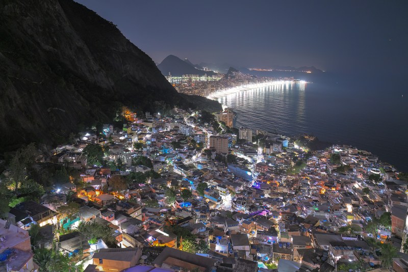 The houses of Vidigal lit up at night below the Dois Irmãos