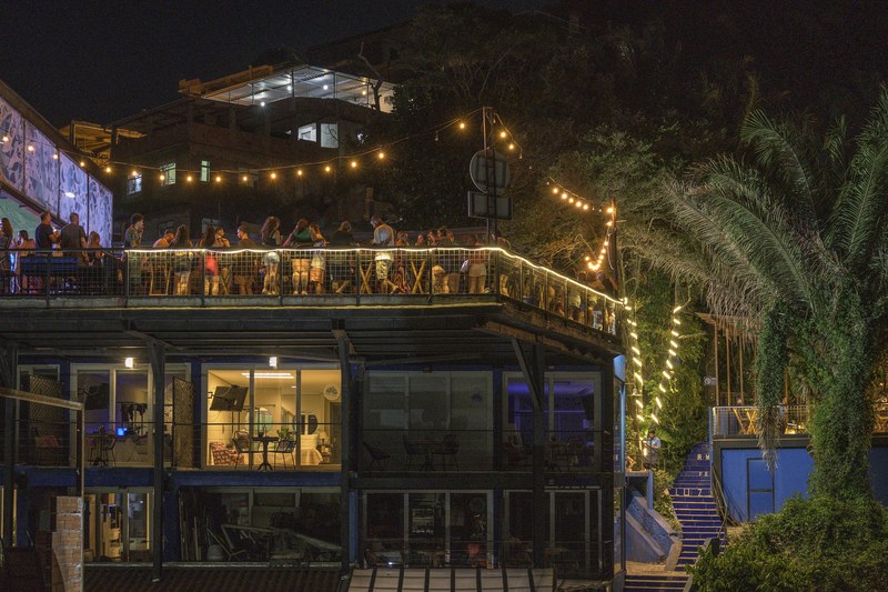 A building with a lit terrace and string lights at night in Vidigal