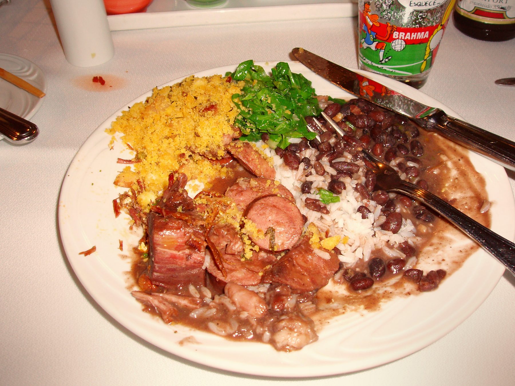 Teller Feijoada — brasilianischer Eintopf aus schwarzen Bohnen mit Reis und Orange